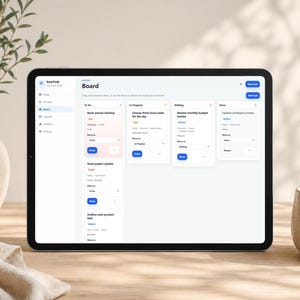 Może przedstawiać: Czarny tablet wyświetla cyfrową tablicę zarządzania zadaniami z tekstem "EasyTask". Interfejs pokazuje listy rzeczy do zrobienia, zadania w toku i ukończone elementy. Wazon z zielenią i ceramiczny kubek znajdują się na pierwszym planie.