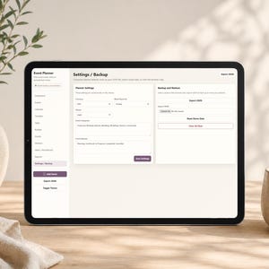 May include: A black tablet displaying an event planner app interface with settings and backup options. The screen shows various settings like currency, time, and event categories. A vase with greenery and a ceramic cup are in the background.
