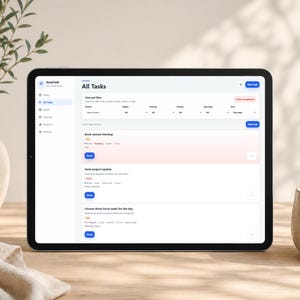 Może przedstawiać: Czarny tablet wyświetlający interfejs aplikacji "EasyTask", z ekranem zarządzania zadaniami zatytułowanym "All Tasks". Ekran zawiera listy zadań, filtry wyszukiwania i niebieski przycisk "Add task". Beżowy wazon i ceramiczny kubek znajdują się w tle.