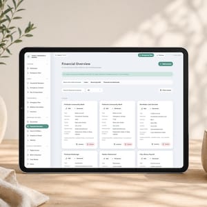 May include: A tablet displaying a digital financial overview dashboard titled Family Emergency Binder. The interface features a sidebar with navigation categories and a main area showing bank and credit account details with edit and archive buttons.