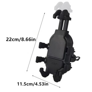 May include: A black car phone holder, measuring 8.66 inches (22 cm) in height and 4.53 inches (11.5 cm) in width. The holder features adjustable arms and a secure grip for various phone sizes. The product has the text "JOR" on the front.
