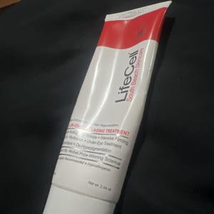 Pu&ograve; includere: Un tubo bianco di LifeCell South Beach Skincare N-ONE Anti-Aging Treatment. Il tubo ha una parte superiore rossa e presenta testo come "Acting", "Wrinkle", "Intensive Firming" e "Net wt. 72 g."