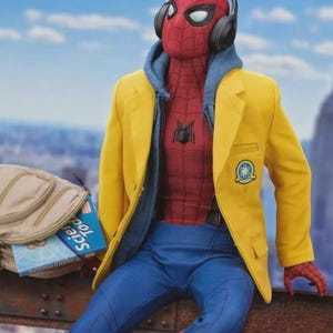 Puede incluir: Figura de acci&oacute;n de Spider-Man con un traje rojo y azul, una sudadera con capucha azul, una blazer amarilla y pantalones azules. La figura lleva auriculares negros y est&aacute; sentada en una viga de metal. Una mochila y un libro est&aacute;n cerca.