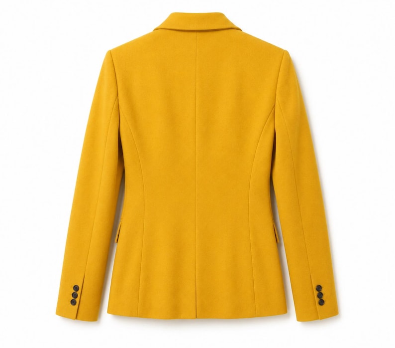 Puede incluir: Vista trasera de una blazer amarillo mostaza con solapa de muesca y tres botones en cada pu&ntilde;o. La chaqueta entallada tiene un dise&ntilde;o cl&aacute;sico y est&aacute; hecha de una tela lisa. La blazer es de color liso y tiene un corte entallado.