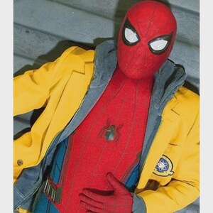 Puede incluir: Un disfraz rojo y azul de Spider-Man con una m&aacute;scara roja y lentes blancos. El disfraz est&aacute; cubierto por una chaqueta amarilla con una sudadera con capucha gris debajo. Un peque&ntilde;o emblema est&aacute; en el pecho del disfraz.