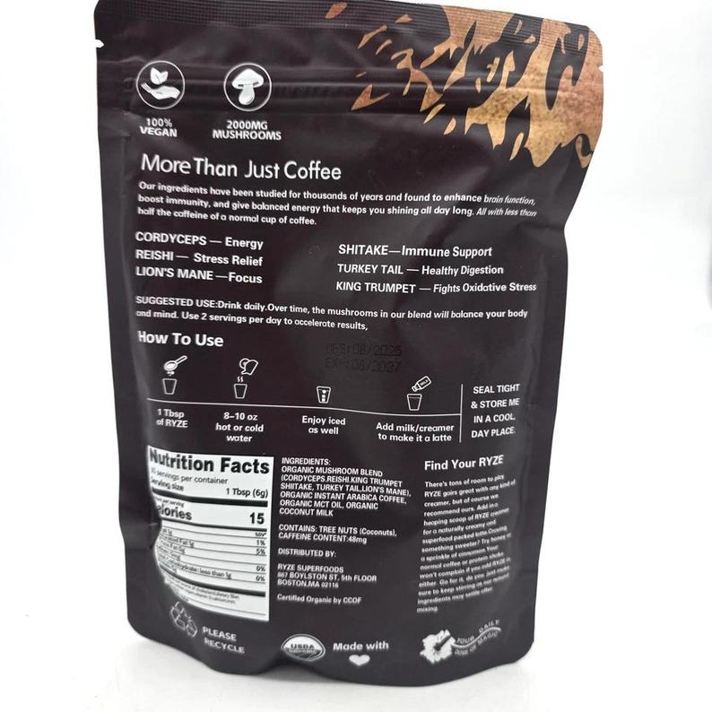 May include: A black pouch of RYZE mushroom coffee blend. The packaging features text detailing ingredients like Cordyceps and Lion's Mane, and instructions for use. The bag also states it is vegan and contains 2000mg of mushrooms.