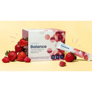 May include: A box of Unicity Balance dietary supplement with the text "The smart solution to balanced nutrition". The box is white and red, with a mixed berry flavor. Fresh strawberries and raspberries are arranged around the box and a single packet.