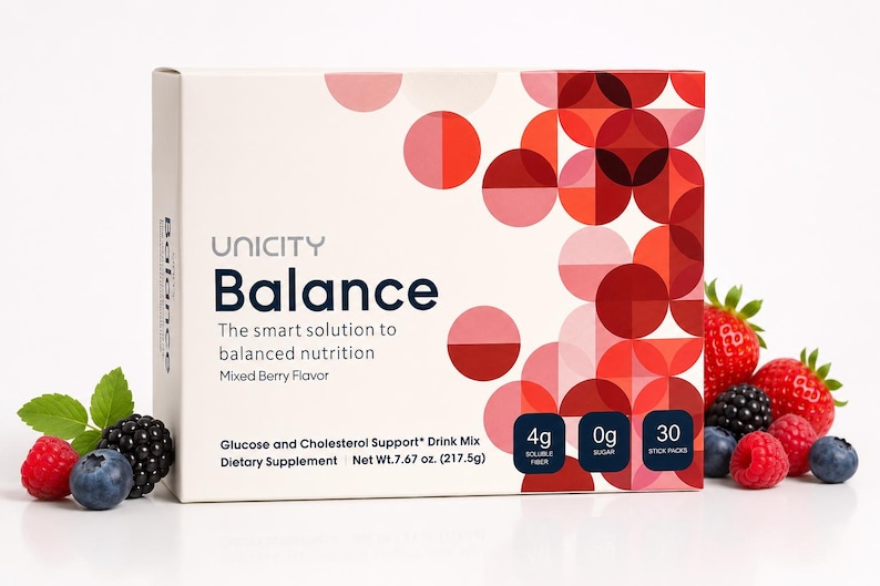 May include: A white box of Unicity Balance, a dietary supplement with a mixed berry flavor. The box features a geometric design in shades of red and pink. Fresh berries, including strawberries, blueberries, and blackberries, are arranged around the box.