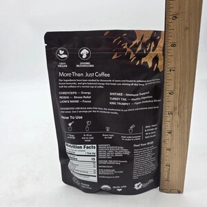 May include: A black pouch of "More Than Just Coffee" mushroom blend. The package includes text about the product's ingredients, benefits, and usage instructions. The package also includes nutritional information and is marked as vegan.