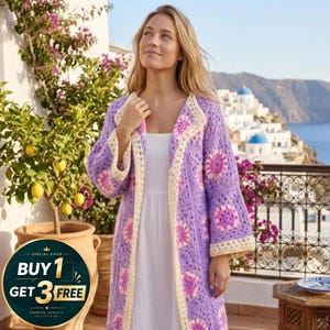 May include: A long, open-front crochet cardigan in shades of lavender, cream, and pink. The floral pattern and open weave create a bohemian aesthetic. The cardigan is worn over a white dress. The image also includes a promotional offer.