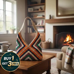 May include: A vibrant, hand-crocheted shoulder bag featuring a geometric design in orange, green, navy, and cream. The bag has a cream strap and is placed on a wooden table. The image also includes the text "BUY 1 GET 3 FREE".