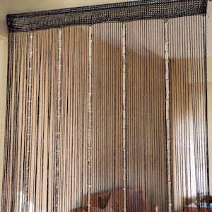 May include: A black string curtain featuring a solid woven header at the top. The curtain is composed of numerous thin, vertical black strands interspersed with several vertical columns of clear, reflective, rectangular beads that catch the light.