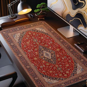 May include: A rectangular desk mat featuring a detailed red, navy blue, and cream floral pattern reminiscent of a traditional Persian rug. The mat has a central medallion design with intricate borders and a smooth, flat surface texture.