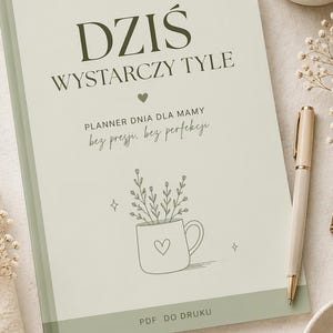 May include: A light green planner with the text "DZIŚ WYSTARCZY TYLE" and "PLANNER DNIA DLA MAMY". The cover features a line drawing of a mug with a heart and flowers. A pen, coffee cup, and paper clips are also visible.