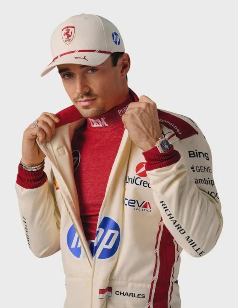 May include: A cream-colored baseball cap with a red Ferrari logo and blue HP branding, paired with a matching cream and red racing jacket featuring various sponsor logos including HP, UniCredit, Ceva Logistics, Bing, and Richard Mille text.