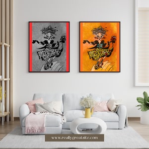 May include: Two framed artworks showing a dancing figure. One is monochrome with a red border, the other in yellow and orange. The figure wears a detailed dress and holds a flower. The artwork is displayed above a white sofa.