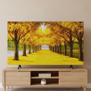 Può includere: Un dipinto di paesaggio su uno schermo televisivo raffigura un sentiero fiancheggiato da alberi in autunno. Gli alberi hanno foglie giallo dorato, creando un effetto tunnel. Anche il terreno è giallo e un fiume è visibile a sinistra.