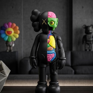 May include: A black vinyl figure with a dissected anatomical design. The figure's right side reveals internal organs in vibrant colors, including a pink brain, yellow lungs, and blue intestines. The left side is solid black with an "X" on the eye. A colorful flower and a bear figure are in the background.
