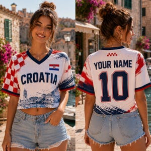 May include: A white short-sleeve jersey with red and white checkered patterns on the sleeves, the text CROATIA on the front, and the text YOUR NAME and the number 10 on the back. The design includes a small Croatian flag and a blue cityscape graphic.