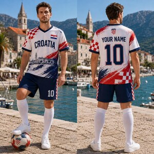 Puede incluir: Un conjunto de f&uacute;tbol blanco, rojo y azul que incluye una camiseta con cuello en V con el texto CROATIA, un gr&aacute;fico de una ciudad costera y una peque&ntilde;a bandera croata. El pantal&oacute;n corto a juego lleva el n&uacute;mero 10, con calcetines blancos y bal&oacute;n.