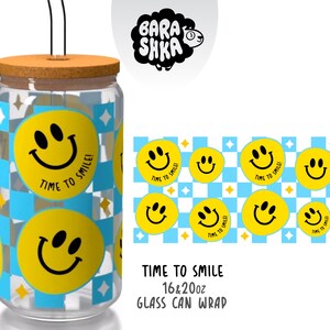 Op de afbeelding: Een heldere glazen beker in de vorm van een blikje met een kurken deksel en een zwart rietje. De beker heeft een herhalend patroon van gele smiley-gezichten en een blauw-witte geruite achtergrond. De tekst "TIME TO SMILE!" staat op de beker.