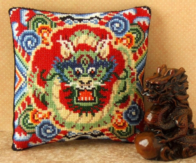 Cross stitch kit for a red, blue, green and yellow mini cushion with a Chinese dragon design. Oriental patterns feature around the border.
