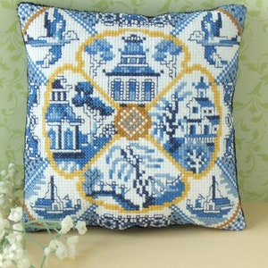 May include: Blue and white embroidered pillow with a floral design featuring a pagoda, trees, and boats. The pillow is surrounded by a yellow border.