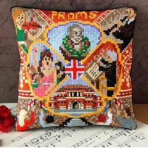 以下が含まれることがあります： 建物、王冠、王冠をかぶった人など、さまざまな画像が刺繍されたカラフルな枕。枕には「PROMS」という文字が刺繍されています。