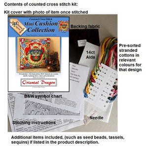 Contents of a counted cross stitch kit for a mini cushion featuring an Oriental Dragon design. The kit includes 14 count Aida fabric, DMC threads on a card, a needle, backing fabric, a chart, and instructions. The kit includes pre-sorted stranded cottons in relevant colours for the design.