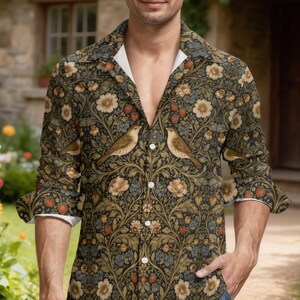 May include: A long-sleeved button-down shirt featuring a dark green botanical pattern with repeating illustrations of brown birds, cream-coloured flowers, and red strawberries. The shirt has a classic collar and white buttons down the front placket.