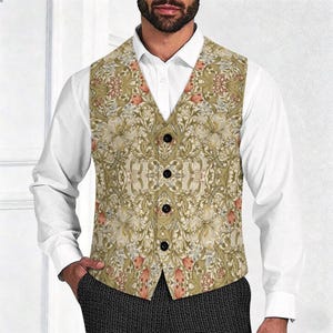 Puede incluir: Un chaleco sin mangas con un patr&oacute;n bot&aacute;nico detallado en tonos verde oliva, crema y naranja apagado. La prenda tiene un escote en V y se abrocha con cuatro botones negros en la parte delantera central, sobre una camisa blanca de manga larga.