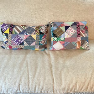 May include: Two rectangular throw pillows featuring a patchwork design made from various fabric scraps. The pillows display a multitude of colors and patterns, including floral, plaid, gingham, and polka dot prints, stitched together in a quilt-like style.