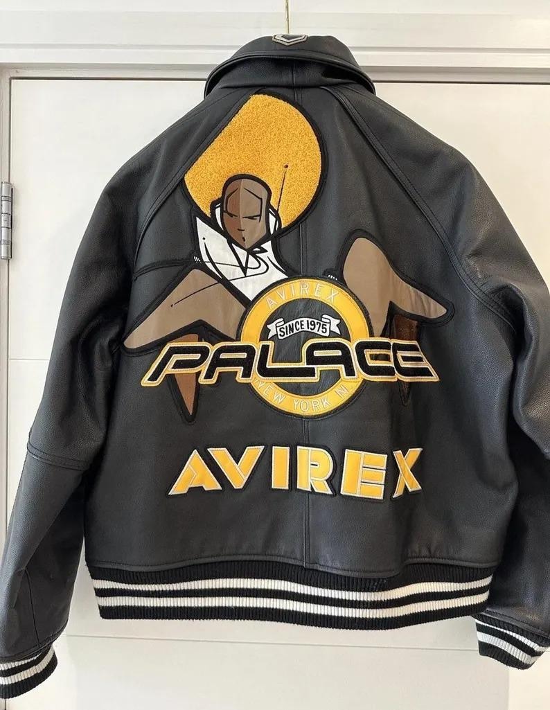 May include: Black leather jacket with a large graphic on the back featuring a seated figure with an afro, and the words "AVIREX PALACE NEW YORK NY" in yellow and white. The jacket has a black and white striped hem.