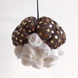 Christmas tree ball with a golden touch!
The upper side is covered by big fabric flowers in black and golden tones. 
The bottom side is composed of delicate white roses adding an elegant feeling.
This is a perfect addition to your Christmas tree