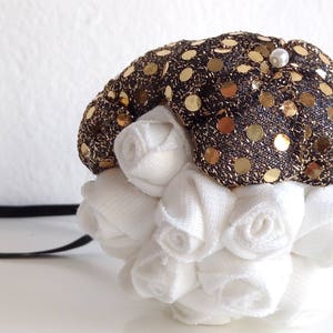 Christmas tree ball with a golden touch!
The upper side is covered by big fabric flowers in black and golden tones. 
The bottom side is composed of delicate white roses adding an elegant feeling.
This is a perfect addition to your Christmas tree