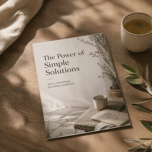 May include: A softcover book titled The Power of Simple Solutions: How to Stop Making Everything Complicated. The cover features a photograph of a small ceramic cup and a notebook on a wooden table, with a plant in the background.