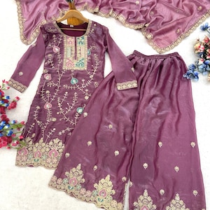 Op de afbeelding: Een geelgroen geborduurd driedelig ensemble. De set bevat een tuniek met lange mouwen, een broek met wijde pijpen en een bijpassende sjaal. De tuniek en broek hebben ingewikkelde gouden en pastelkleurige borduursels.