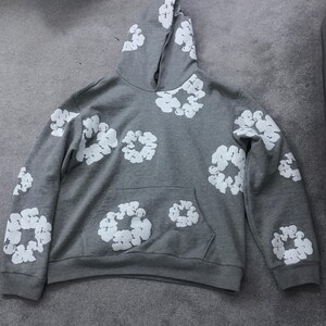 May include: A gray hoodie with a white floral pattern. The hoodie has a kangaroo pocket and a drawstring hood. The white floral pattern is repeated across the front, back, and sleeves of the hoodie.