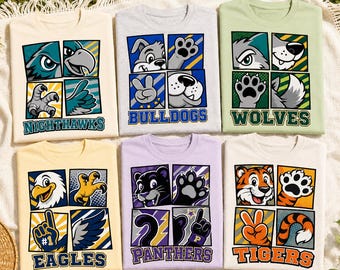 May include: Six t-shirts featuring graphic prints of animal mascots including Nighthawks, Bulldogs, Wolves, Eagles, Panthers, and Tigers. Each shirt displays a four-panel grid design with cartoon illustrations of animal faces, paws, and team names.