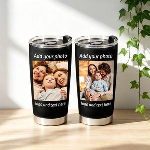 May include: Two black insulated tumblers with silver rims and lids. Each tumbler features a family photo and the text "Add your photo" and "logo and text here". The tumblers are on a light brown surface.