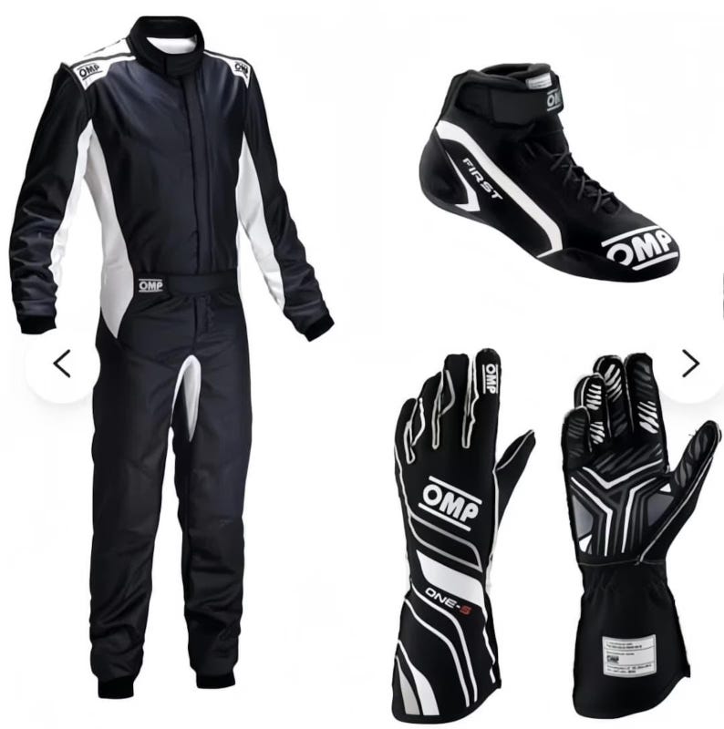 May include: A black and white OMP racing suit, a high-top racing shoe with the text FIRST, and a pair of black and white racing gloves with the text OMP and ONE-S. The racing suit features a high collar, long sleeves, and a full-length zipper closure.