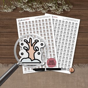 May include: Two sheets of planner stickers featuring a repeating pattern of small, light pink trees with black outlines and white snow accents. A magnifying glass focuses on one sticker, and a black pen rests on the sheets near a copper penny.