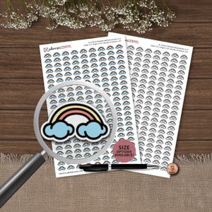 May include: Two sheets of planner stickers featuring rows of small rainbow icons, one sheet in color and one in black and white. A magnifying glass highlights a single rainbow sticker. Text includes "plannerloom" and "SIZE OPTIONS AVAILABLE!"