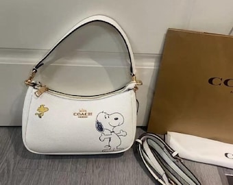 Peanuts Teri Shoulder Bag in chalk white pebble leather featuring Snoopy and Woodstock motifs