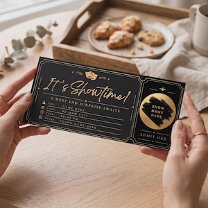 May include: A black rectangular ticket with gold foil accents featuring the text It's Showtime! A West End surprise awaits. The design includes theatre mask icons, lines for name, date, time, and venue, and a circular gold foil patch with the text Show Name Here and Admit One.