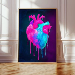 May include: A rectangular wall art print featuring a stylized anatomical heart illustration against a dark background. The heart is rendered in vibrant neon pink and bright cyan blue, with paint-like drips flowing downward from the base.