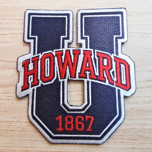 Peut inclure: Un écusson brodé bleu marine en forme de grande lettre U avec une bordure blanche. Le mot HOWARD est cousu en rouge au centre et l'année 1867 est cousue en rouge en bas. L'écusson présente une finition en tissu texturé.