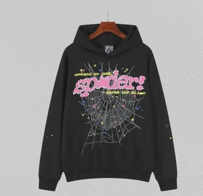 May include: Black hooded sweatshirt with a graphic design featuring a spider web, the word "spider!" in pink, and the phrases "nevermind the punk" and "have the slime" in yellow. The design includes stars and colourful accents.