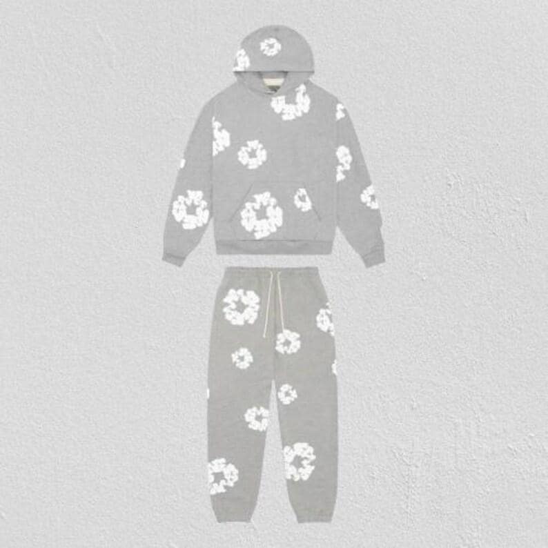 May include: A gray hoodie and sweatpants set with a white floral pattern. The hoodie has a drawstring hood and a front pocket. The sweatpants have a drawstring waist. The set is made of a soft, comfortable material.