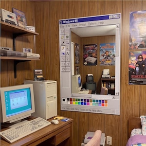 May include: A room decorated with a retro computer theme, featuring a mirror designed as a Windows 95 interface. The mirror is framed in white. The room includes a desktop computer, monitor, keyboard, and retro game consoles.